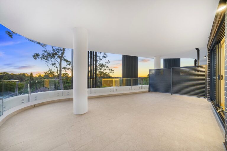 Wide curved balcony with glass balustrade and treetop views at LaCurva